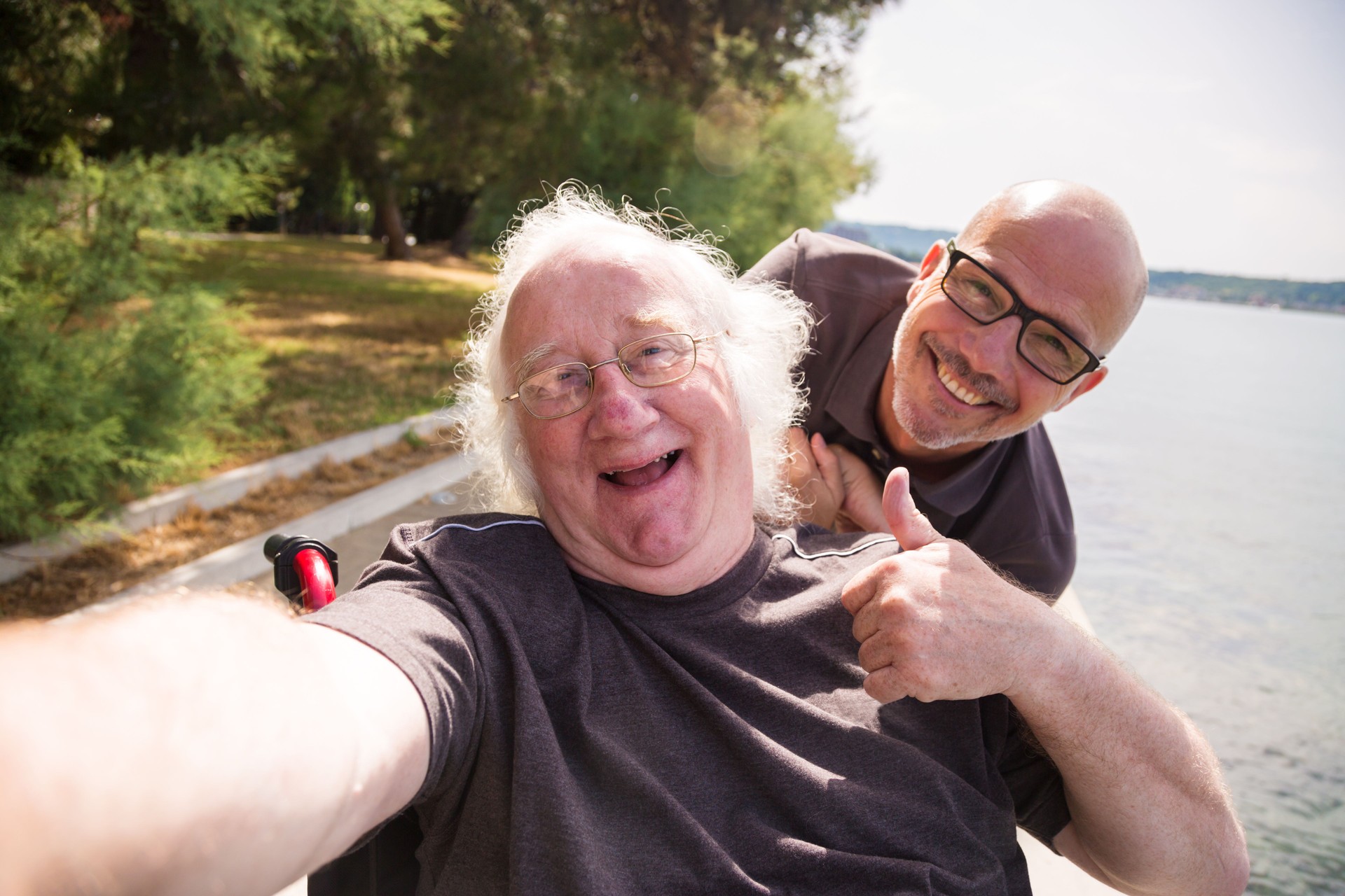 old man in wheelchair taking a selfie with his phone old man in wheelchair taking a selfie with his phone